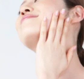 明るい背景で、女性が頬に手のひらを当て、顔全体へなじませるように手を動かしているスキンケアのイメージです。